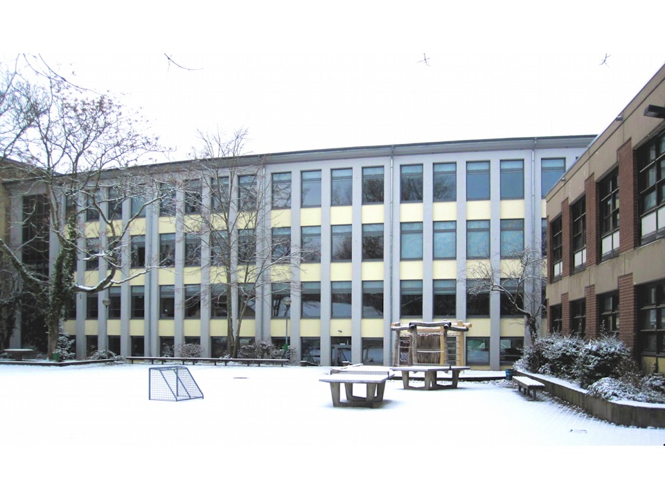 Dem Schulhof zugewandte, im Jahr 2010 erneuerte, Fassade des Hauptgebäudes sowie sportlicher Bewegung dienende Gerätschaften auf dem Hof. 20130209114052#2934